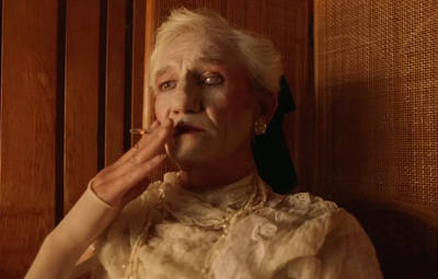 an older woman smoking a cigarette in a room