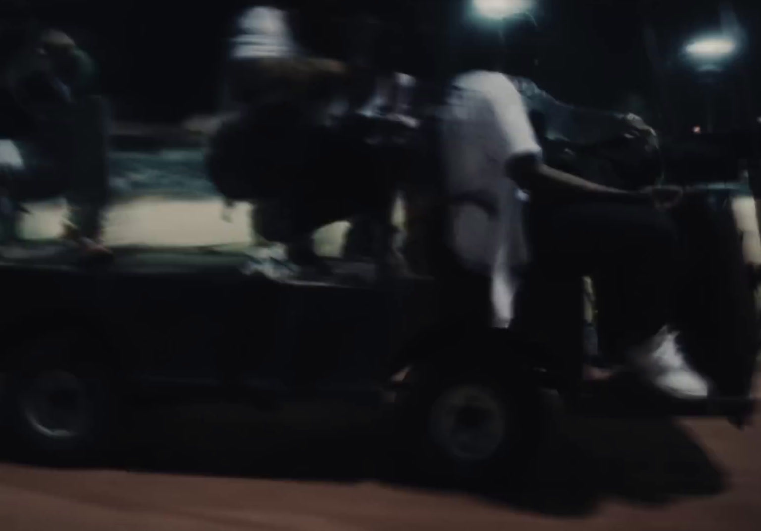 a man riding on the back of a truck at night