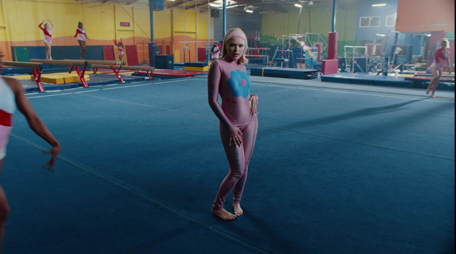 a woman in a pink outfit standing on a blue floor