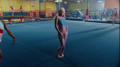 a woman in a pink outfit standing on a blue floor