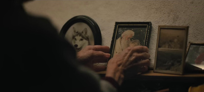 a person holding a picture of a dog in front of a mirror