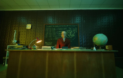 a man standing in front of a blackboard in a room