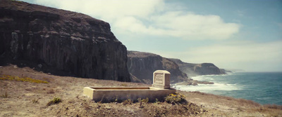 a bench sitting on top of a hill next to the ocean