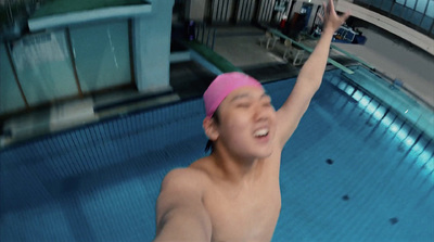 a man in a swimming pool wearing a pink hat