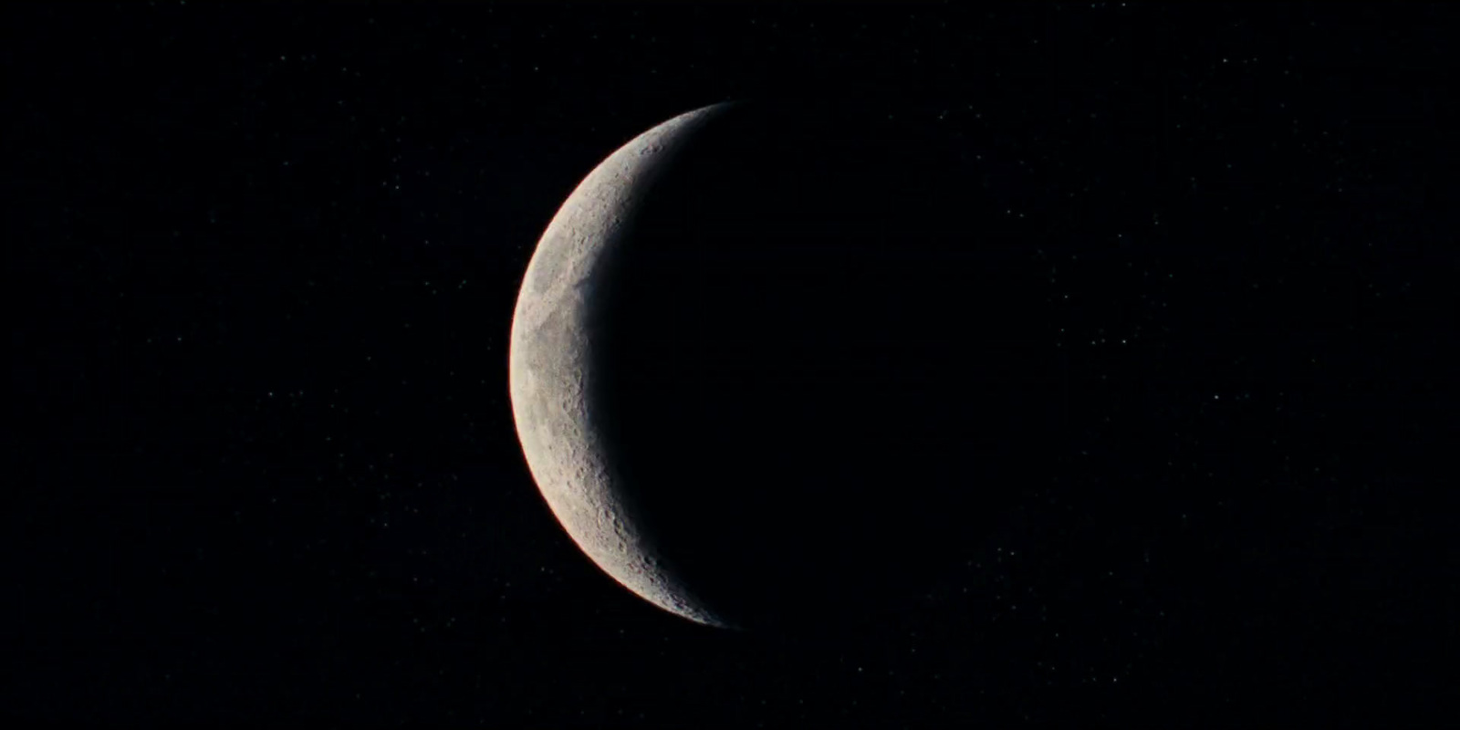 the crescent of the moon in the dark sky