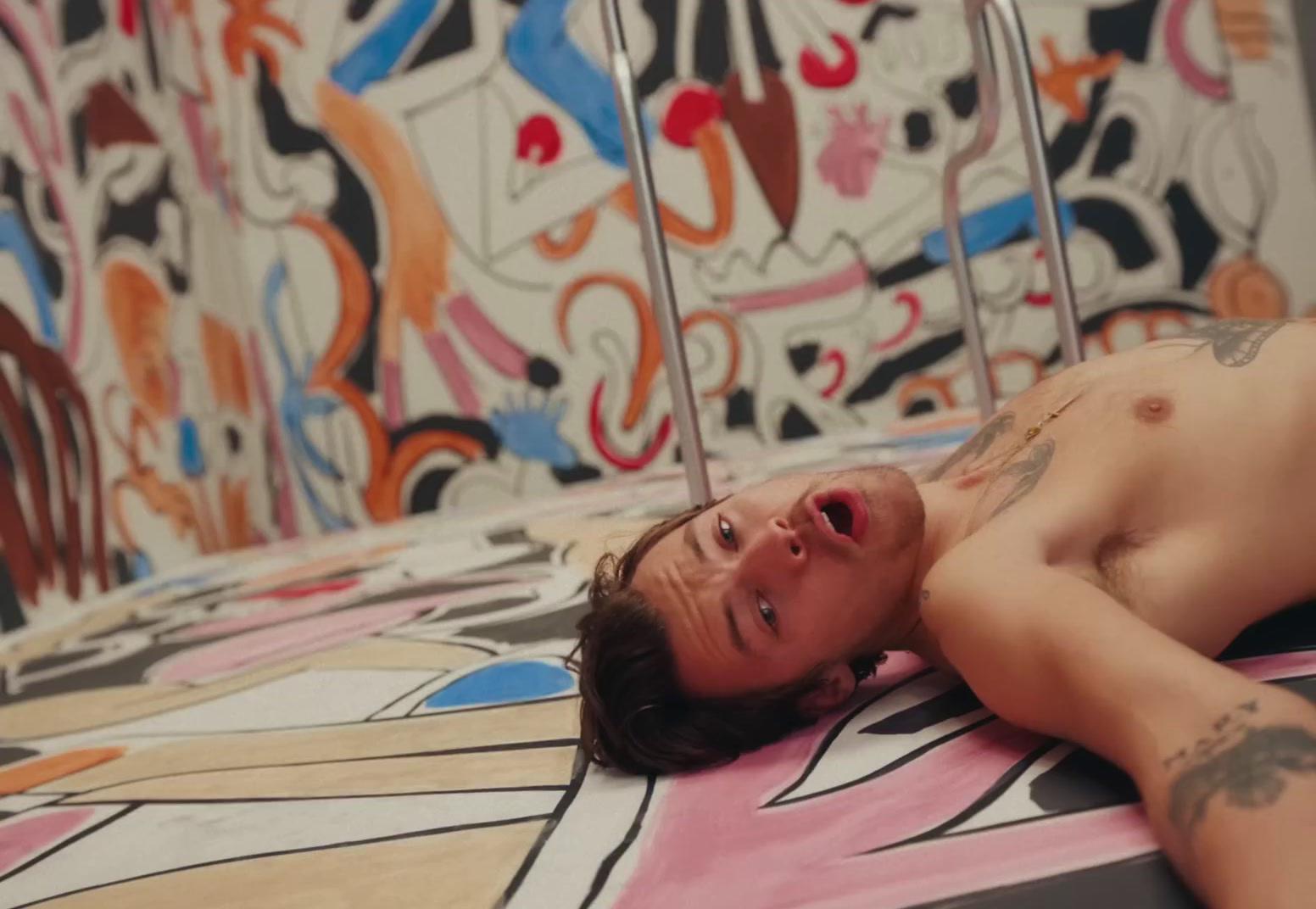 a man laying on top of a bed covered in tattoos