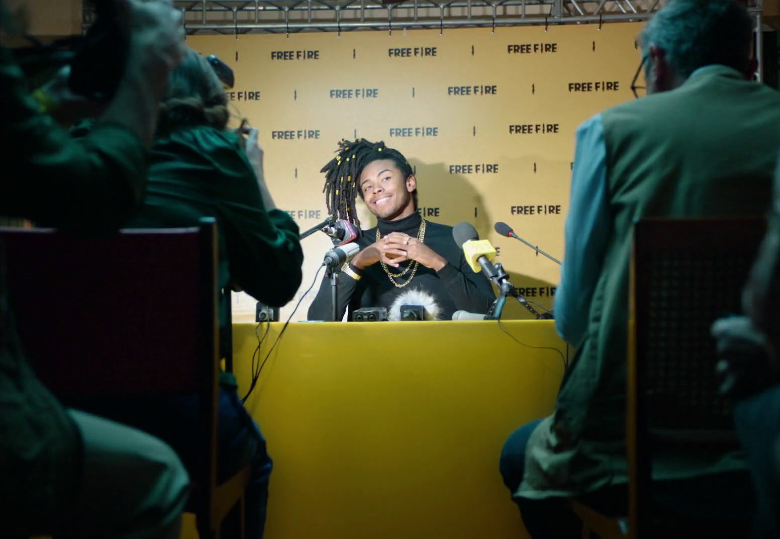 a man with dreadlocks sitting in front of a microphone