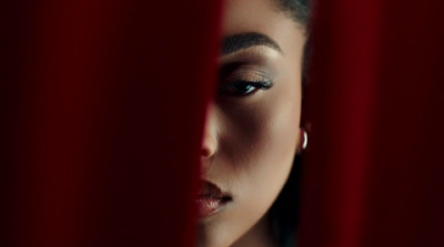 a woman looking through a red curtain