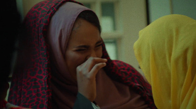 a woman in a red and yellow hijab talking on a cell phone