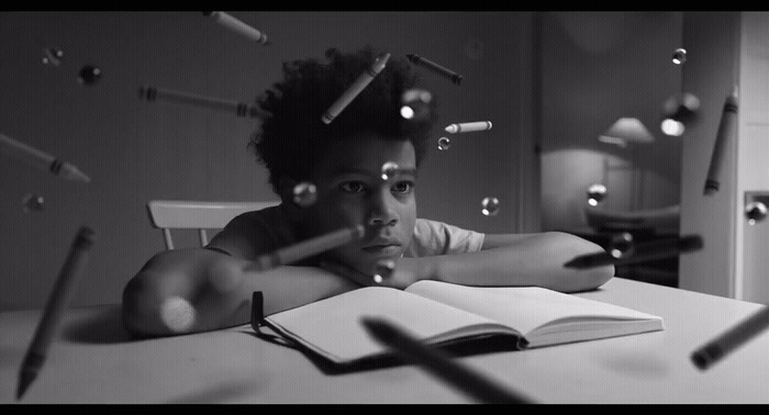 a young man sitting at a table with an open book