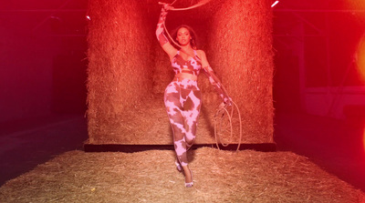 a woman in a pink and white outfit is holding a hula hoop