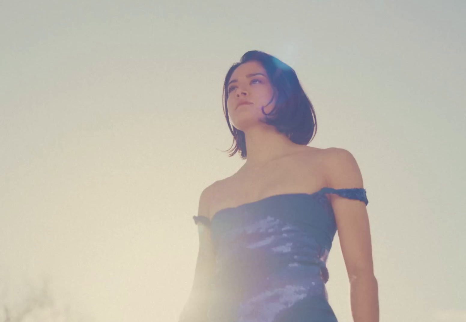 a woman in a strapless dress standing in a field