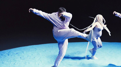 a couple of people standing on top of a blue surface