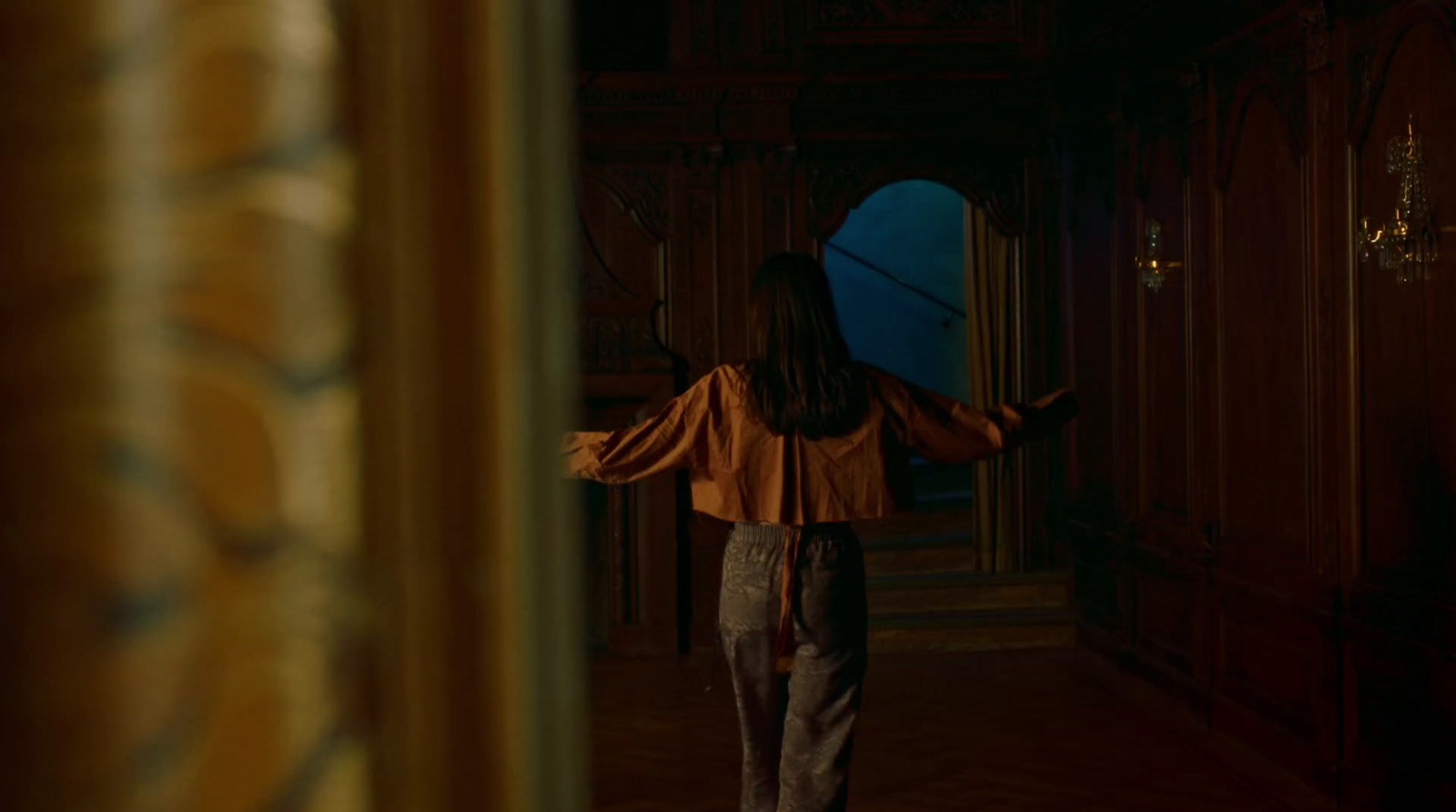 a woman walking down a hallway in a building