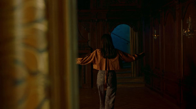 a woman walking down a hallway in a building