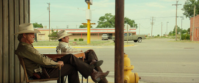 a couple of men sitting on top of a wooden bench