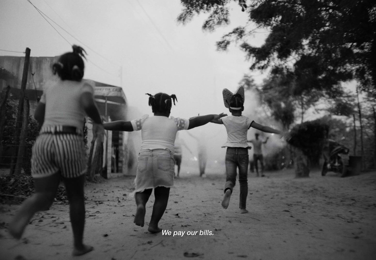 two young girls running down a dirt road