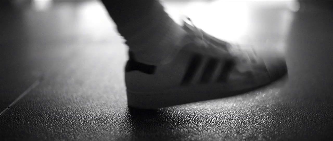 a close up of a person's shoes on a wooden floor