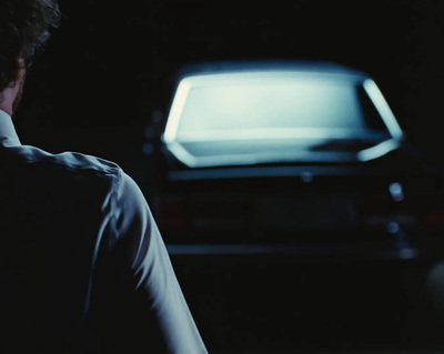 a man sitting in front of a tv in the dark