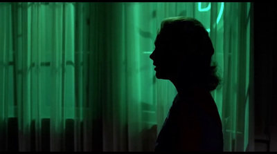 a person standing in front of a green curtain