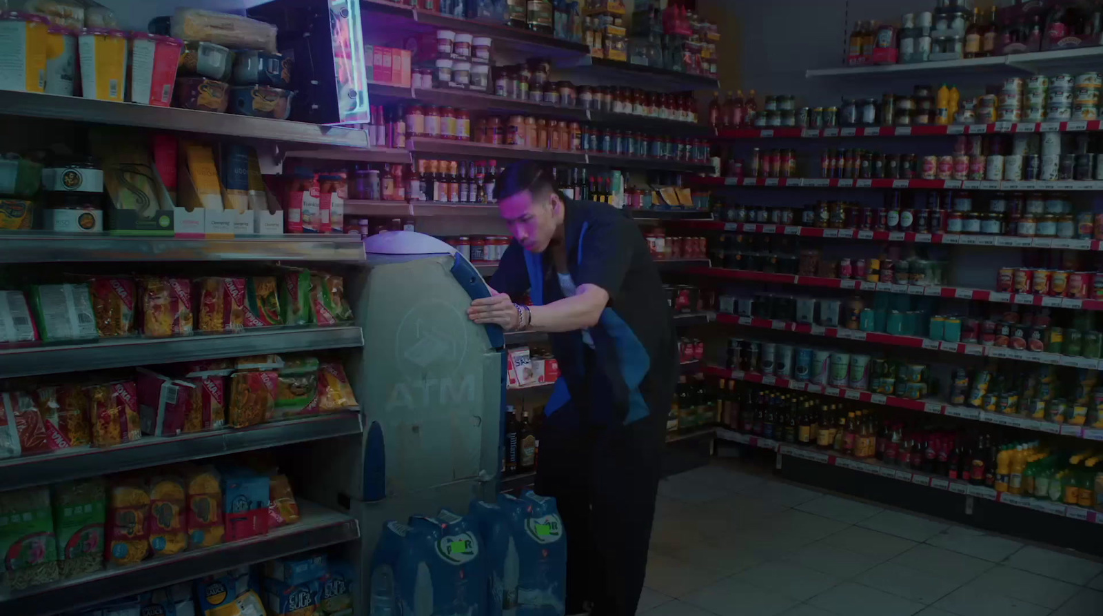 a man standing in a store looking at a cell phone