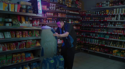 a man standing in a store looking at a cell phone