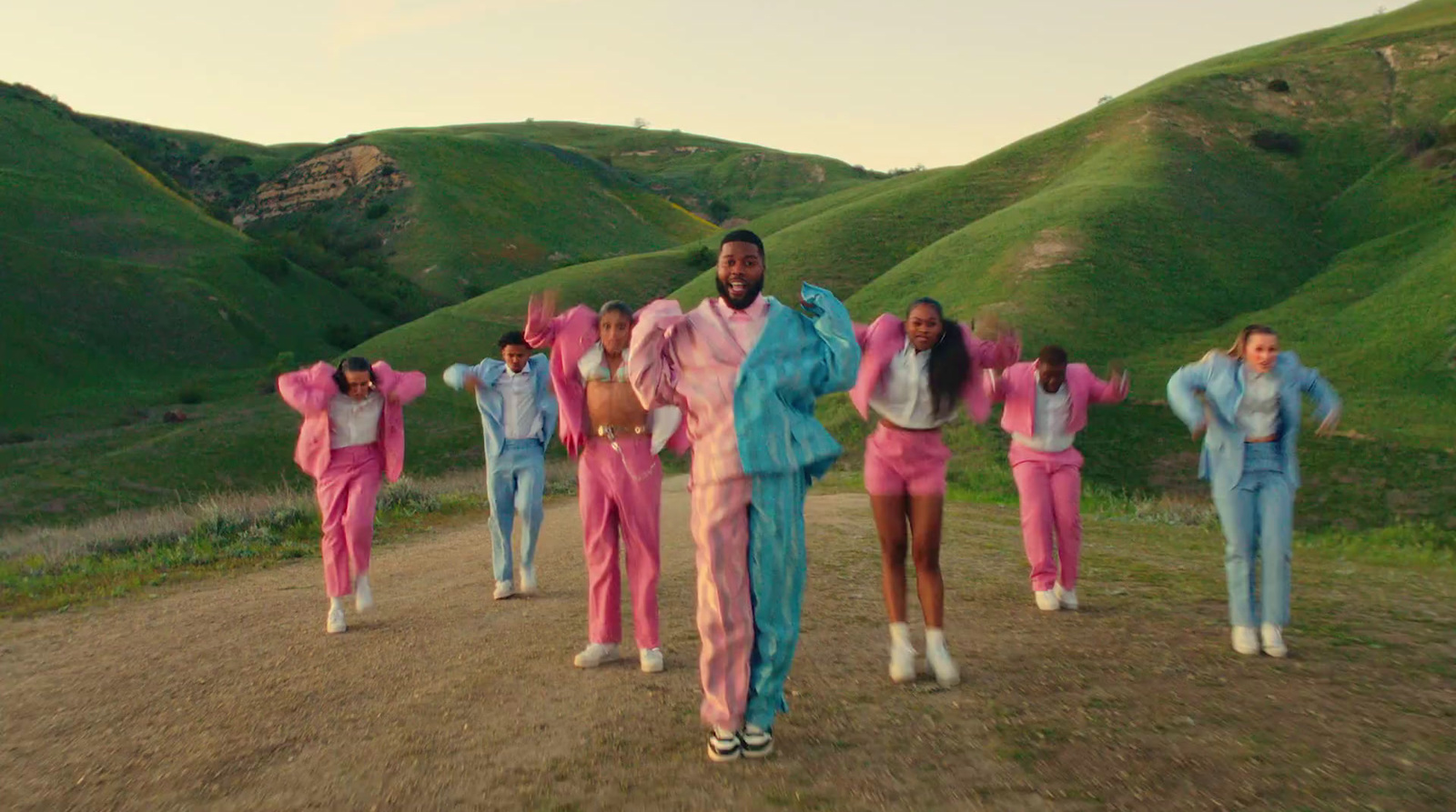 a group of people standing on top of a dirt road