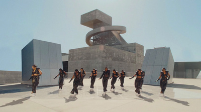 a group of people walking across a cement ground