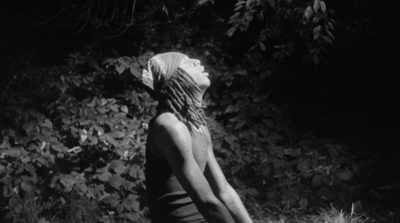 a woman in a bathing suit standing in the grass