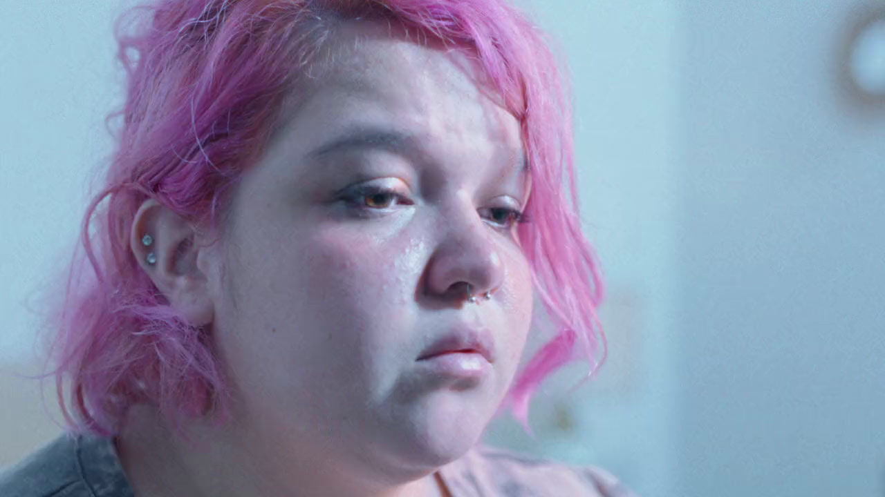 a woman with pink hair and piercings on her nose