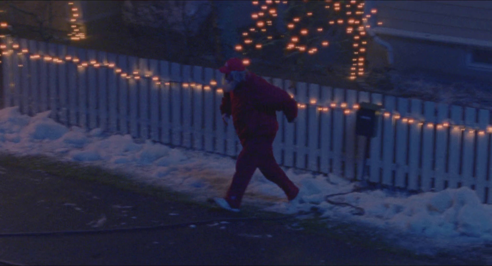 a man walking down a snow covered sidewalk