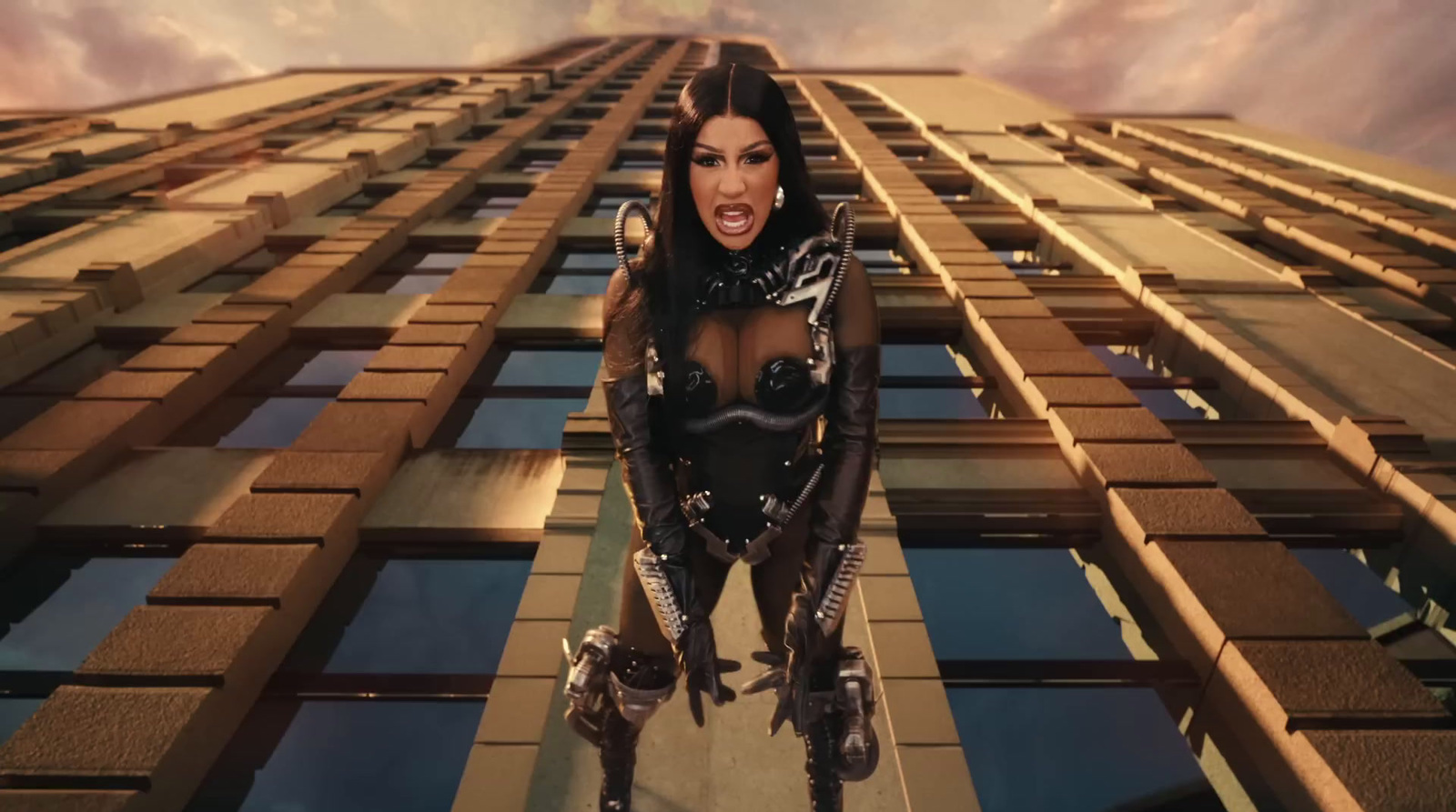 a woman in a futuristic suit standing in front of a building