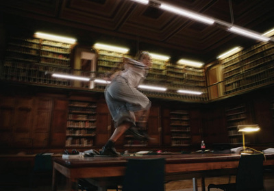 a blurry photo of a person jumping on a table in a library