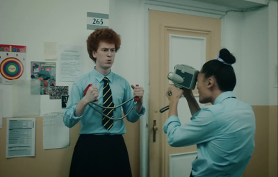 a man in a blue shirt and tie holding a camera