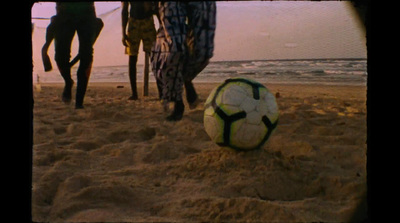 a soccer ball sitting on top of a sandy beach