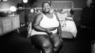 a black and white photo of a woman in a bedroom