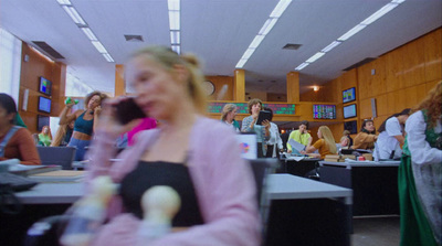 a woman talking on a cell phone in a room full of people