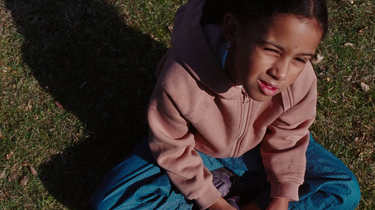 a little girl sitting on the ground with a frisbee