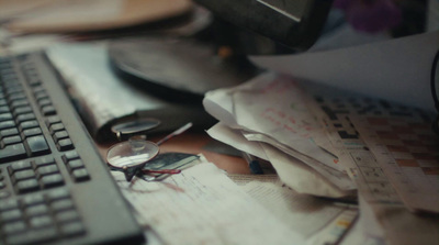 a computer keyboard sitting on top of a pile of papers