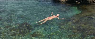 a man is swimming in the clear blue water