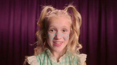 a little girl with blue polka dots on her face