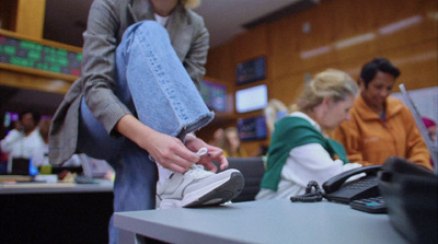 a woman putting on a pair of sneakers