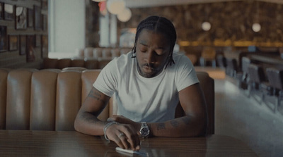 a man sitting at a table using a cell phone