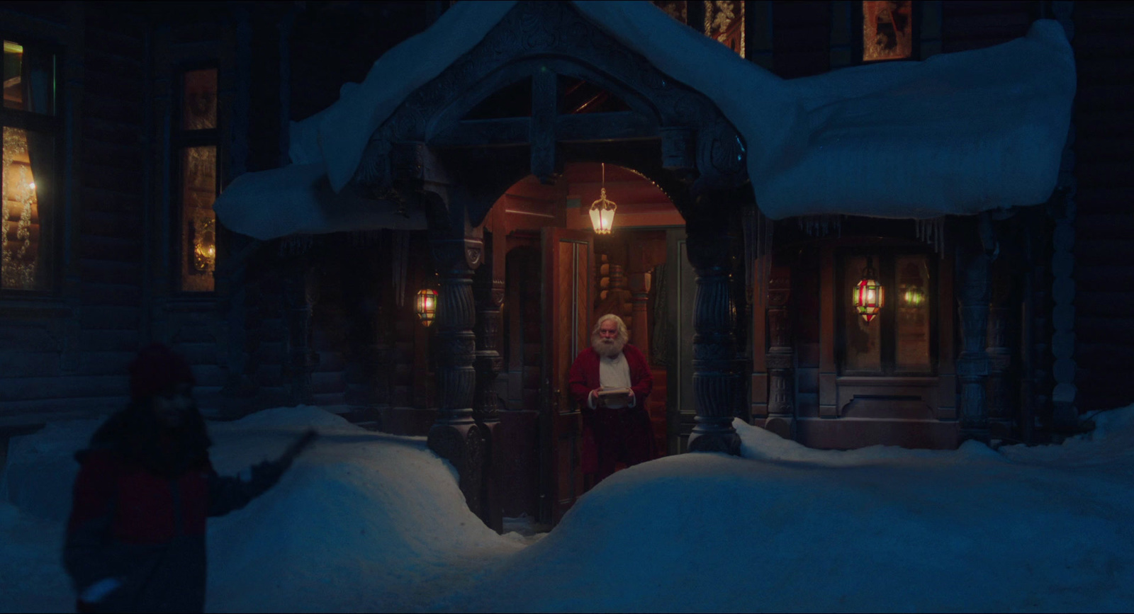 a woman standing in front of a house in the snow