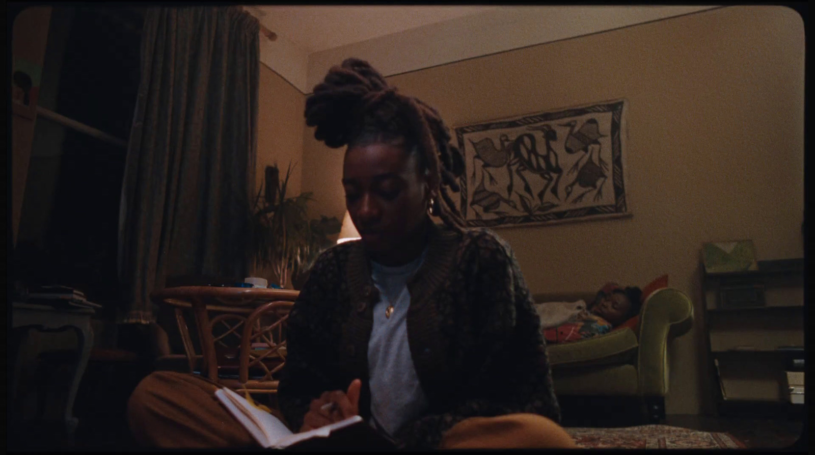 a woman sitting on a bed reading a book