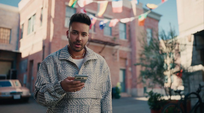 a man standing on the street looking at his cell phone