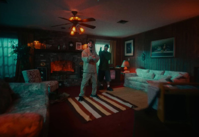 a man standing in a living room next to a fire place