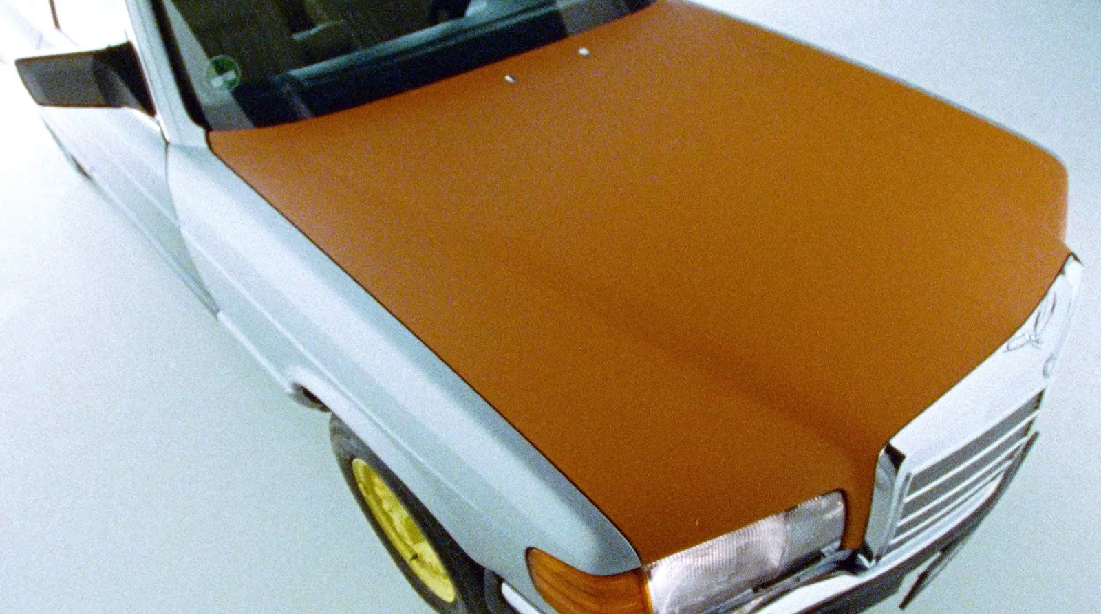 a brown and white car parked in a garage