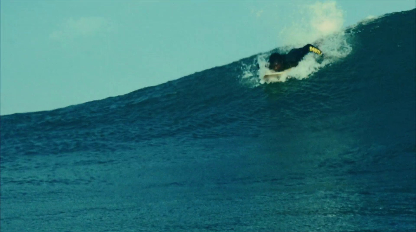 a man riding a wave on top of a surfboard