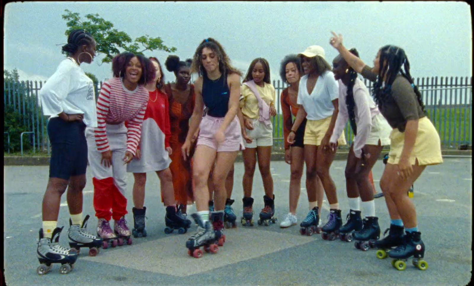 a group of young women standing around each other on roller skates